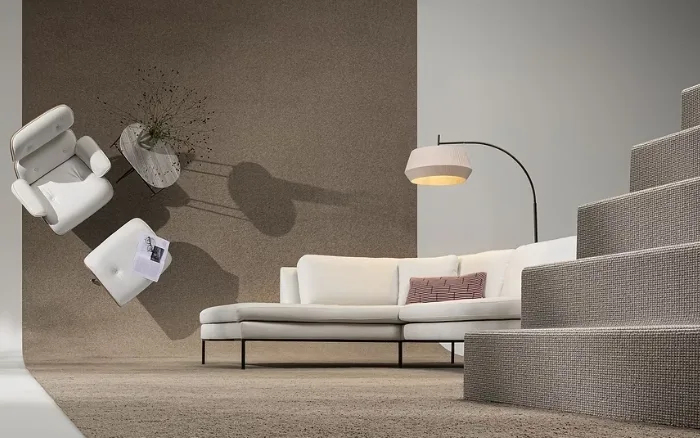 Woonkamer met wollen tapijt in beige, witte bank en stoel en design lamp.