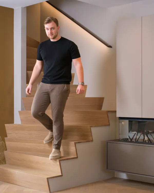 Licht eiken Z-trap in de woonkamer met een heer er op