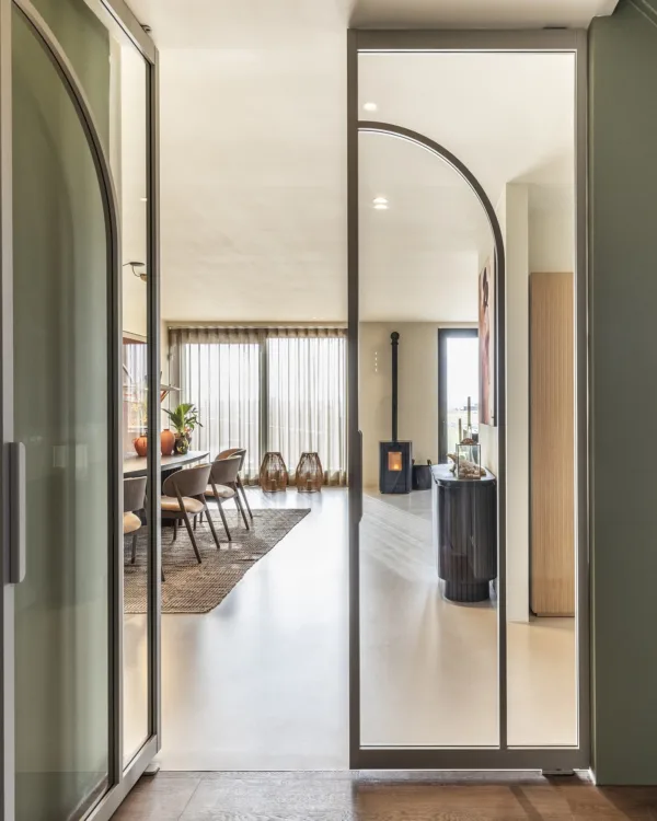 Moderne woning met Art Nouveau elementen zoals steel look deuren met gebogen frame en organisch gevormde meubels
